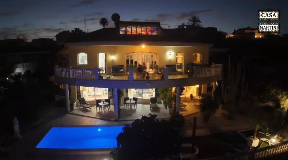 Das beleuchtete Haus mit blauem Pool bei Nacht